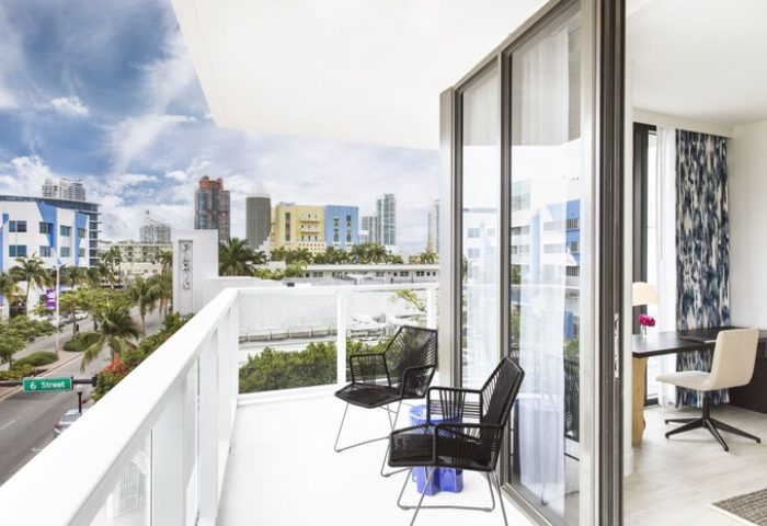 Kimpton Angler's Hotel balcony view. Gay-friendly hotel room with chairs, table and Miami skyline. Perfect for gay travel and relaxation.