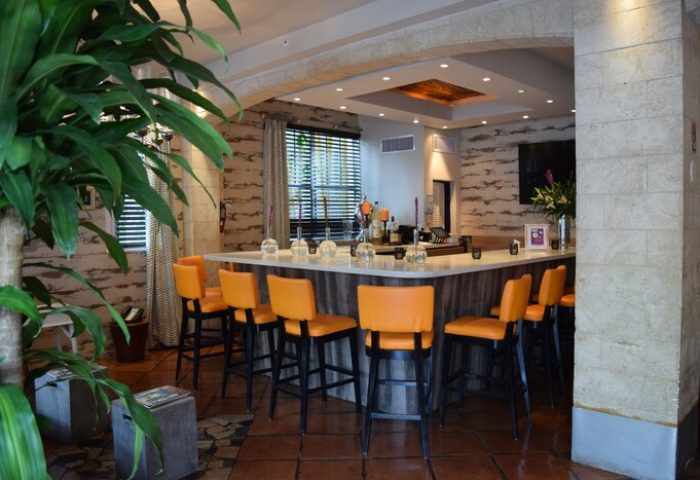 Hotel Shelley bar area. Gay-friendly hotel features stylish bar with orange stools, stone walls, and modern decor. A welcoming space for gay travelers.