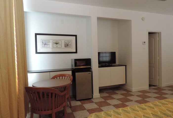 Interior of James Hotel, a gay-friendly hotel. Room with table, chairs, microwave, TV, and checkered floor. Travel advice for gay men.