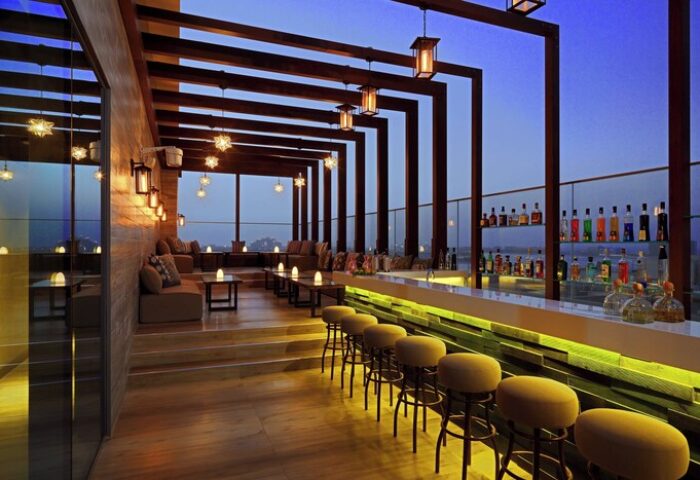 Aloft Palm Jumeirah's stylish rooftop bar. A gay-friendly hotel with chic seating, ambient lighting, and a well-stocked bar for a memorable experience.