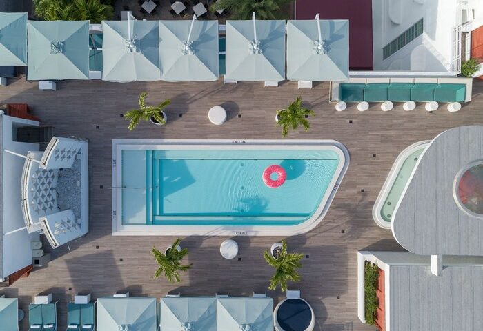 Dream South Beach, a gay-friendly hotel: aerial view of the pool with a pink float, umbrellas, and lounge chairs. Part of Hyatt hotels.