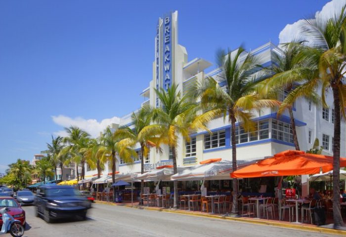 Breakwater Hotel South Beach facade. A gay-friendly hotel with Art Deco architecture, palm trees, and outdoor dining in Miami Beach.