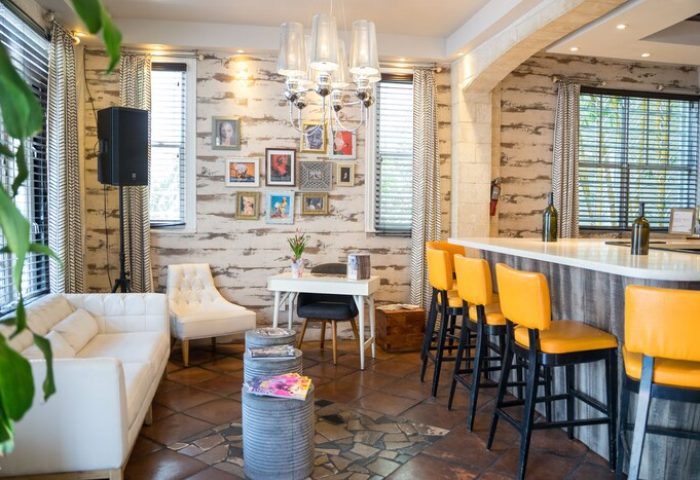 Hotel Shelley's gay-friendly interior. Lounge area with white sofa, yellow bar stools, and eclectic decor. A welcoming space for gay travelers.
