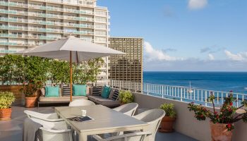 Hilton Vacation Club The Modern Honolulu gay-friendly hotel terrace. Ocean view, table, chairs, and lounge seating. Ideal for gay men travel.