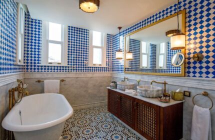 Hagia Sofia Mansions Istanbul bathroom. Luxurious gay-friendly hotel room with blue diamond tiles, marble sinks, and patterned floor. Curio Collection.