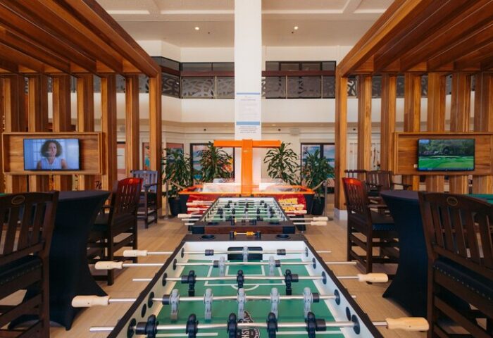 Game room at Waikiki Beach Marriott Resort & Spa, a gay-friendly hotel. Foosball tables, TVs, and seating provide entertainment for guests.
