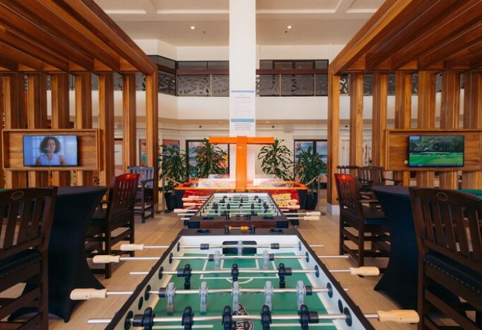 Game room at Waikiki Beach Marriott Resort & Spa, a gay-friendly hotel. Foosball tables, TVs, and seating provide entertainment for guests.