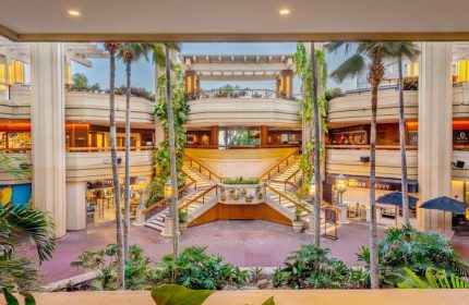 Hyatt Regency Waikiki Beach Resort & Spa interior. Palm trees, stairs, and shops. Gay-friendly hotel in Hawaii for gay men travel.