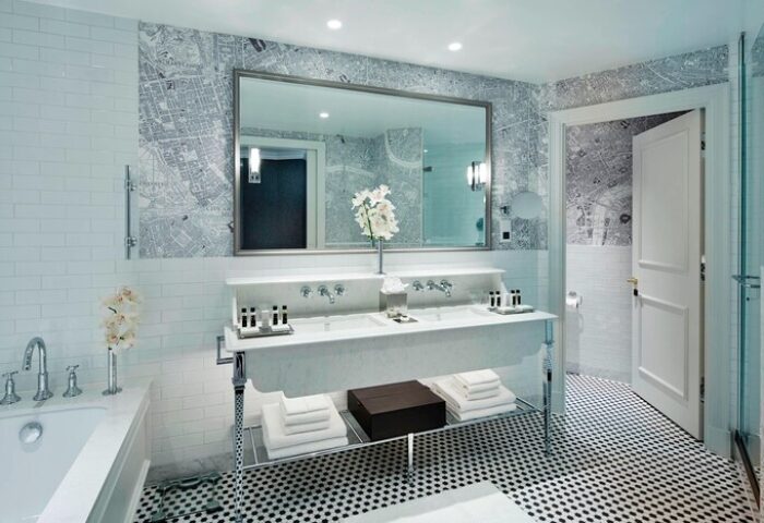Bathroom at London Marriott Hotel County Hall, a gay-friendly hotel. Double sink, map wallpaper, black and white tile. Upscale design.