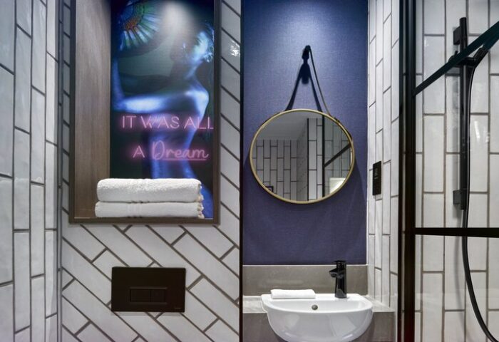 NYX Hotel London Holborn bathroom. Gay-friendly hotel detail: sink, mirror, shower, and art with It was all a dream text. Modern design.