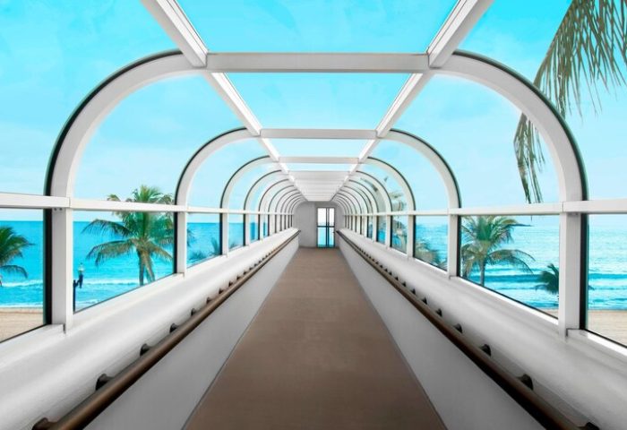 The Westin Fort Lauderdale Beach Resort skywalk. Gay-friendly hotel with ocean views, palm trees, and a covered walkway to the beach.