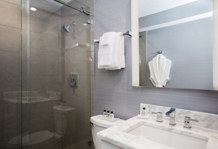 Elita Hotel gay-friendly bathroom. Shower, sink, mirror, and towels in a modern design. Luxurious amenities for gay travel and a comfortable stay.