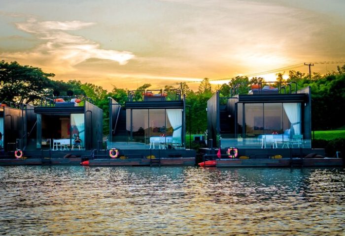 Cross River Kwai hotel's floating villas on the River Kwai. A gay-friendly hotel with modern design and scenic views at sunset.