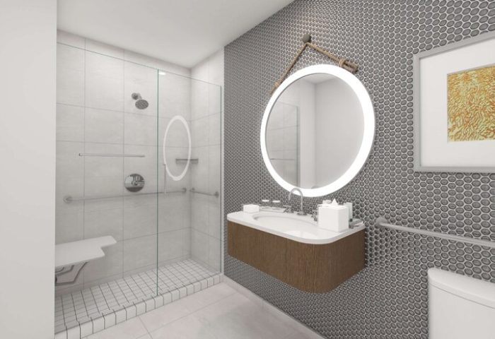 The Reach Key West, Curio Collection by Hilton gay-friendly hotel bathroom. Shower with seat, round mirror, and modern sink.