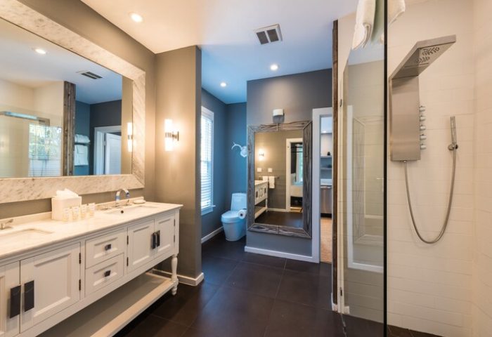 Alexander's Guesthouse bathroom. Gay-friendly hotel with double vanity, large mirror, toilet, and shower. Modern design for gay men travel.