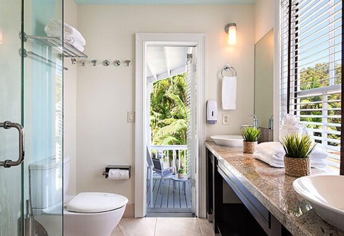 NYAH Key West gay-friendly hotel bathroom. Shower, toilet, and double sink vanity. Balcony view. Adults only travel.