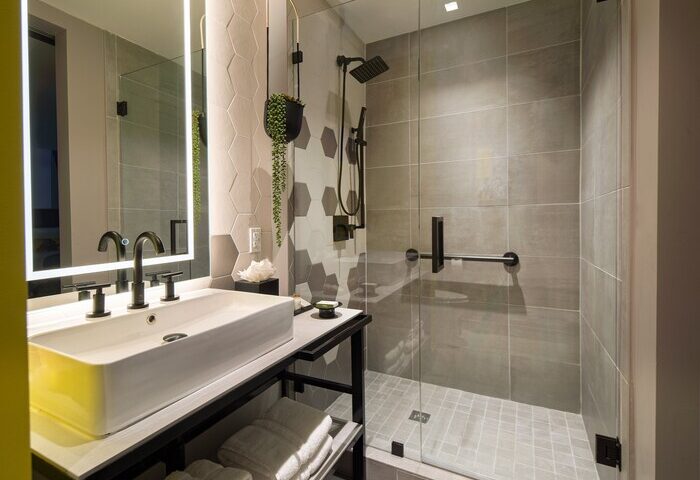 Hotel Indigo Miami Brickell bathroom. Modern design with walk-in shower, sleek sink, and hexagonal tile. Gay-friendly hotel for the discerning traveler.