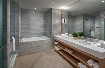 W South Beach gay-friendly hotel bathroom. Features a double sink, large mirror, bathtub, and shower. The gray and white tile gives it a modern look.