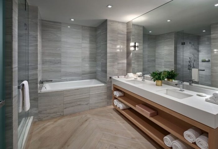 W South Beach gay-friendly hotel bathroom. Features a double sink, large mirror, bathtub, and shower. The gray and white tile gives it a modern look.