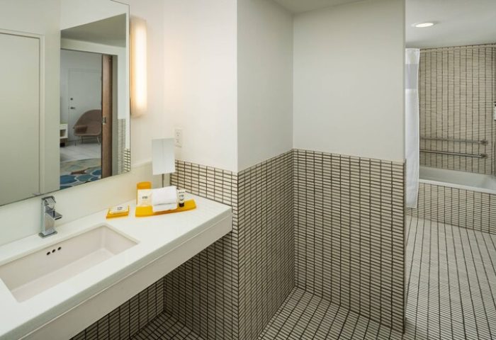 Bathroom at Royal Palm South Beach Miami, a Tribute Portfolio Resort. Gay-friendly hotel features modern design, vanity, and tiled shower/tub.