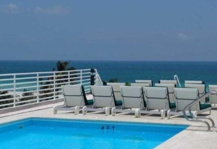 Strand Ocean Drive Suites gay-friendly hotel pool. Lounge chairs overlook the ocean. Perfect for gay men travel.