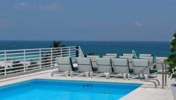 Strand Ocean Drive Suites gay-friendly hotel pool. Lounge chairs overlook the ocean. Perfect for gay men travel.