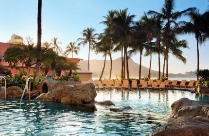 The Royal Hawaiian, a Luxury Collection Resort, Waikiki gay-friendly hotel pool. Palm trees, Diamond Head, and lounge chairs visible.