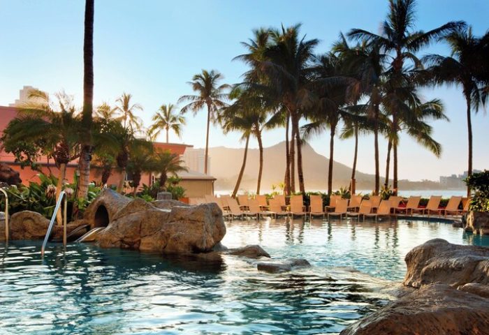 The Royal Hawaiian, a Luxury Collection Resort, Waikiki gay-friendly hotel pool. Palm trees, Diamond Head, and lounge chairs visible.
