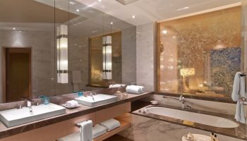 Raffles Istanbul Hotel bathroom. Luxurious, gay-friendly hotel with double sinks, marble, and a bathtub. Perfect for gay travel and relaxation.