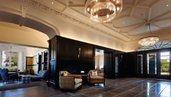 Cameron House on Loch Lomond's gay-friendly hotel interior. Elegant lobby with chandeliers, seating, and dark wood paneling. Upscale travel.