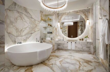 Atlantis The Royal gay-friendly hotel bathroom. Oval tub, round mirror, marble walls, chandelier. Luxury travel for gay men.