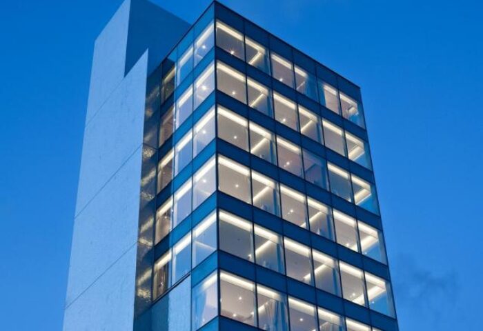 Exterior of 99 Bonham, a gay-friendly hotel. Modern architecture with glass windows and concrete. A great choice for gay travelers.