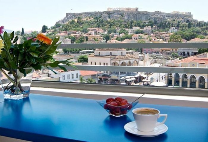 A For Athens Hotel view with coffee, strawberries, flowers, and the Acropolis. Gay-friendly hotel for gay men's travel in Athens.