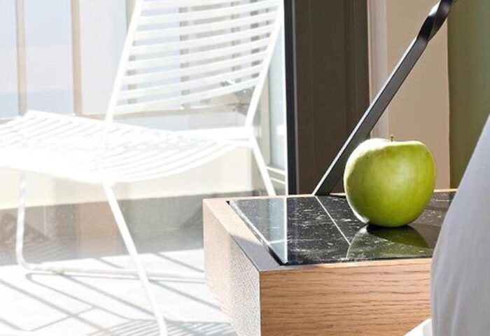 A For Athens Hotel detail. Gay-friendly hotel room with a green apple on a bedside table and a white chair on the balcony.