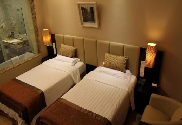 AC Embassy Hotel room with two beds. Gay-friendly hotel featuring modern decor, bathroom view, and comfortable amenities for gay men travelers.