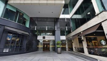 Entrance of gay-friendly ANSA Hotel Kuala Lumpur. Modern architecture with shops. Ideal for gay travelers seeking comfort and style.