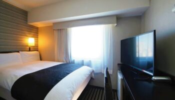 APA Hotel Shinjuku-Gyoemmae room. Gay-friendly hotel room with bed, desk, and TV. Modern decor. Comfortable stay in Shinjuku, Tokyo.