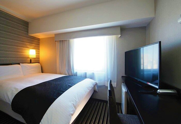 APA Hotel Shinjuku-Gyoemmae room. Gay-friendly hotel room with bed, desk, and TV. Modern decor. Comfortable stay in Shinjuku, Tokyo.