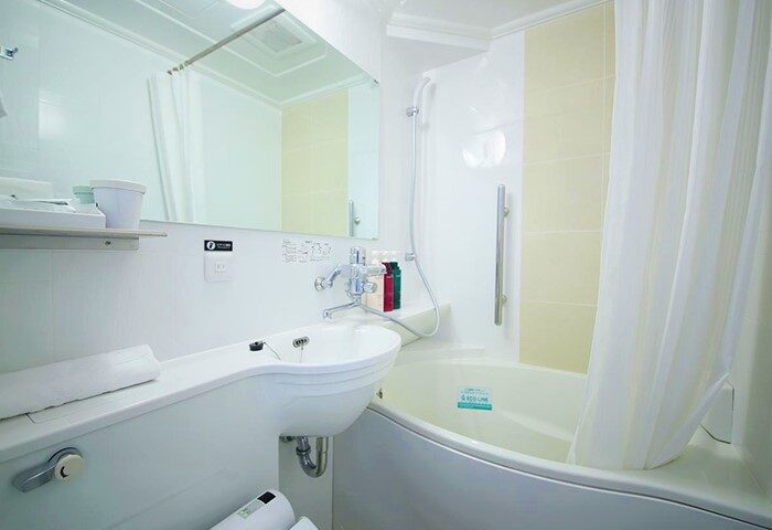 Bathroom at APA Hotel Shinjuku-Kabukicho Tower, a gay-friendly hotel. Features a sink, mirror, bathtub and shower. Great for gay travel.