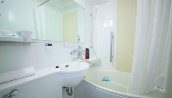 Bathroom at APA Hotel Shinjuku-Kabukicho Tower, a gay-friendly hotel. Features a sink, mirror, bathtub and shower. Great for gay travel.
