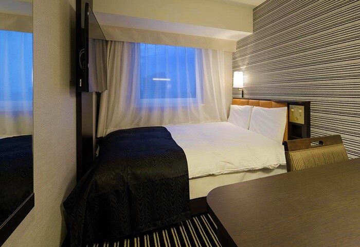 APA Hotel Shinjuku-Kabukicho Tower room interior. Gay-friendly hotel with bed, desk, & TV. Modern design, comfortable for gay travelers.