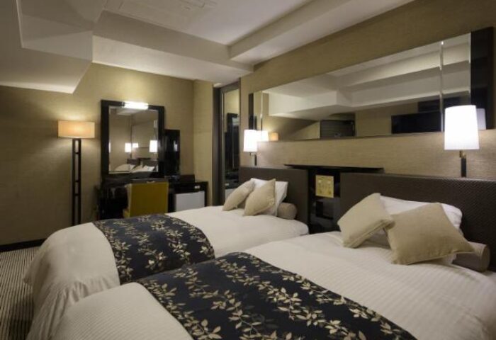 Gay-friendly APA Hotel Shinjuku-Kabukicho Tower room. Twin beds, desk, and mirror. A comfortable stay in Tokyo's vibrant district.