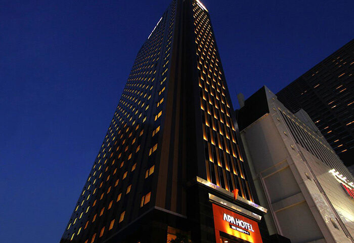 APA Hotel Shinjuku-Kabukicho Tower. A tall, modern building with many windows, lit up at night. Gay-friendly hotel in Tokyo, Japan.