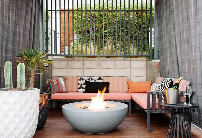 ARRIVE Palm Springs gay-friendly hotel patio with fire pit, seating, and drinks. Outdoor space at a Palm Springs hotel for gay travelers.