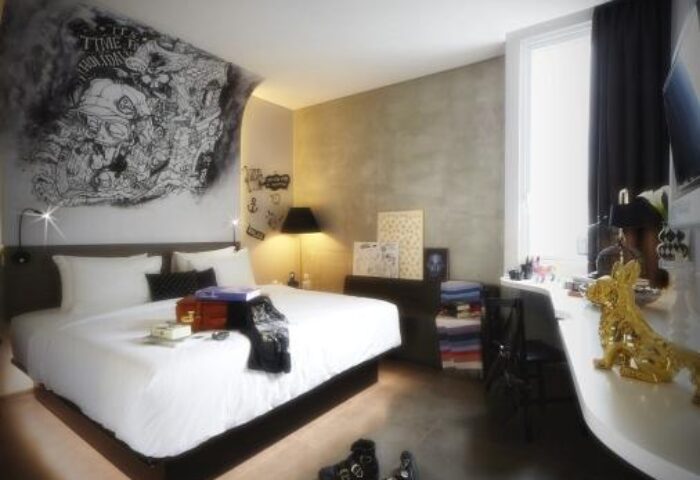 ARTOTEL Thamrin Jakarta gay-friendly hotel room. Modern design, mural art, comfy bed, desk. Ideal for gay travel in Jakarta, Indonesia.
