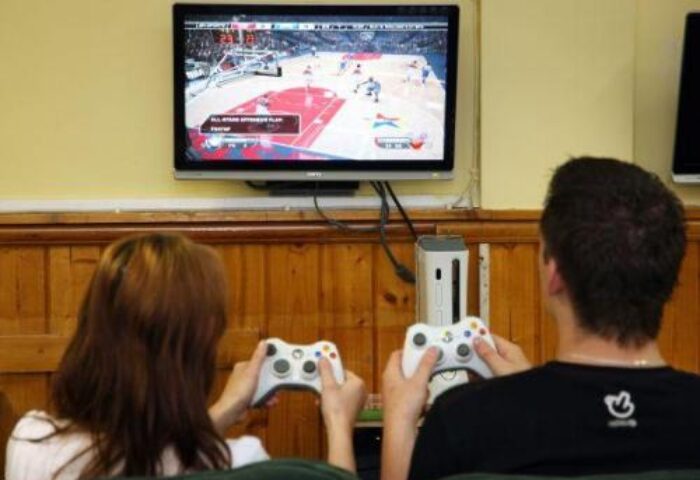 Guests playing video games at Abbey Court Hostel, a gay-friendly hotel. Enjoy gaming during your stay. #GayTravel #HostelLife