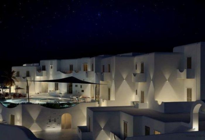 Absolute Mykonos Suites at night. Gay-friendly hotel with white buildings, pool, and stars. Luxury Mykonos travel for gay men.