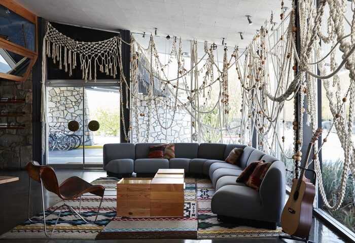 Ace Hotel and Swim Club Palm Springs lobby. Gay-friendly hotel interior with modern furniture, guitar, and macrame decor. Relaxing vibe.