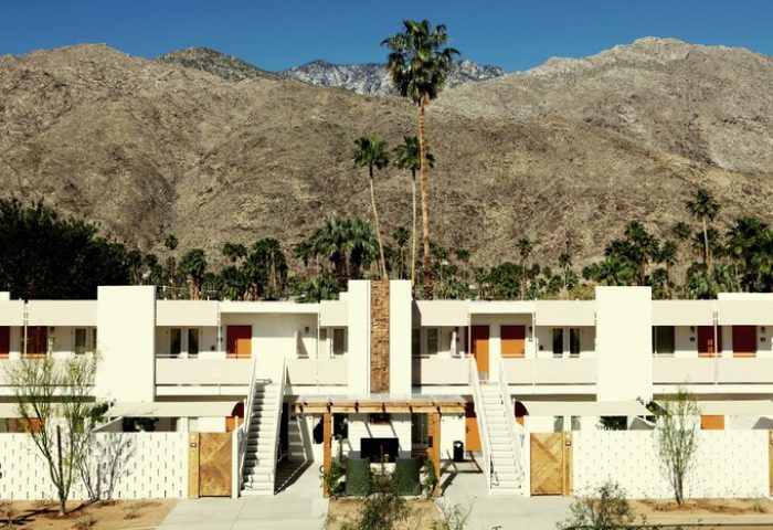 Ace Hotel and Swim Club Palm Springs view. Gay-friendly hotel with mountain backdrop. Modern architecture, palm trees, and desert landscape.
