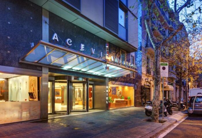 Acevi Villarroel Hotel entrance. Gay-friendly hotel in Barcelona, Spain. Revolving doors, modern design, street view. Gay travel advice.